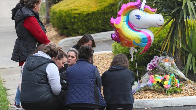 Staff of the childcare centre gather to reflect at a makeshift memorial in front of the centre. Picture: David Crosling