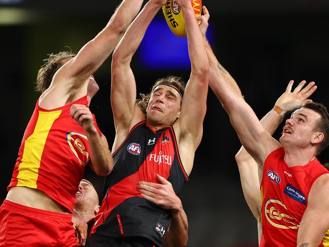 MELBOURNE, AUSTRALIA - JULY 17: Harrison Jones of the Bombers (C) takes a mark during the round 18 AFL match between the Essendon Bombers and the Gold Coast Suns at Marvel Stadium on July 17, 2022 in Melbourne, Australia. (Photo by Graham Denholm/AFL Photos via Getty Images)