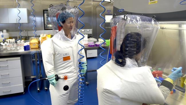 Virologist Shi Zheng-li, left, works with her colleague in the P4 lab of Wuhan Institute of Virology. Picture: Getty Images