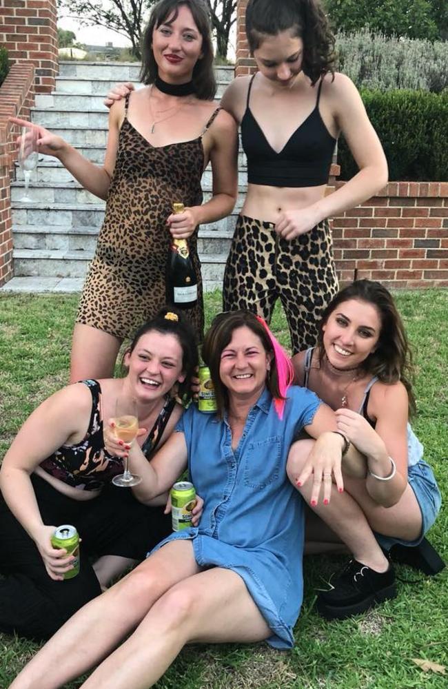 A happy photo of Natalie Joyce and her daughters, (clockwise from bottom left) Caroline, Bridgett (standing, left), Julia (seated, right), Odette (standing, right).