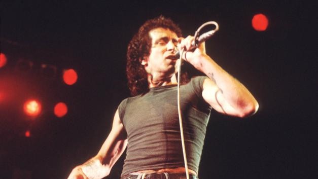 Bon Scott performs on stage with AC/DC, UK, 1976. (Photo by Michael Putland/Getty Images)