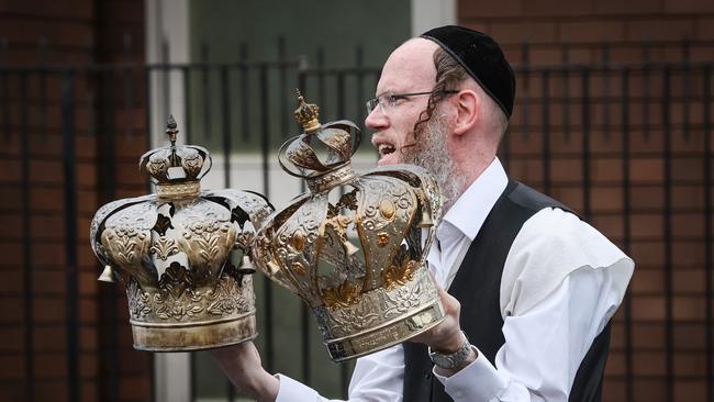 A member of the Jewish community removes religious artefacts from the synagogue. Picture: David Caird