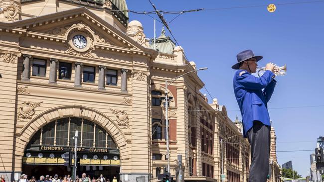 The Last Post being played by Richard Loo rings out over Flinders St Station today. Picture: Wayne Taylor.