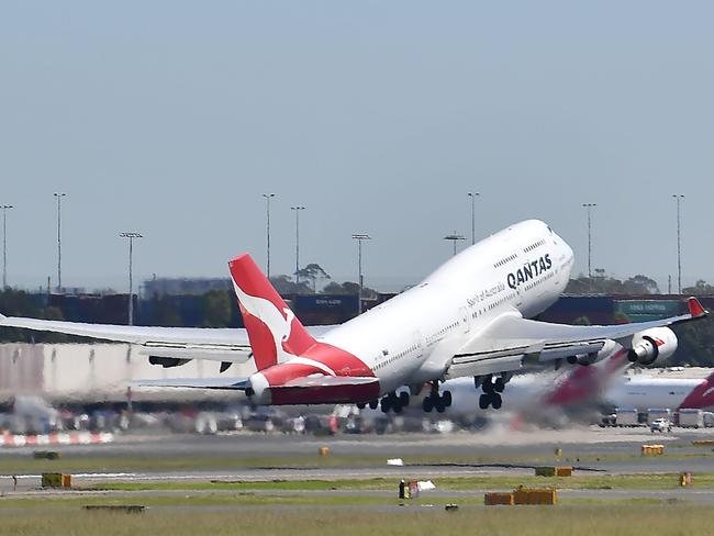 A Qantas Airways plane takes off at Sydney Airport in Sydney on March 19, 2020. - Australia's biggest airline Qantas said it would halt all international flights and suspend 20,000 staff in response to the coronavirus pandemic, days after the island nation's other main carrier Virgin shut its overseas routes. (Photo by Saeed KHAN / AFP)