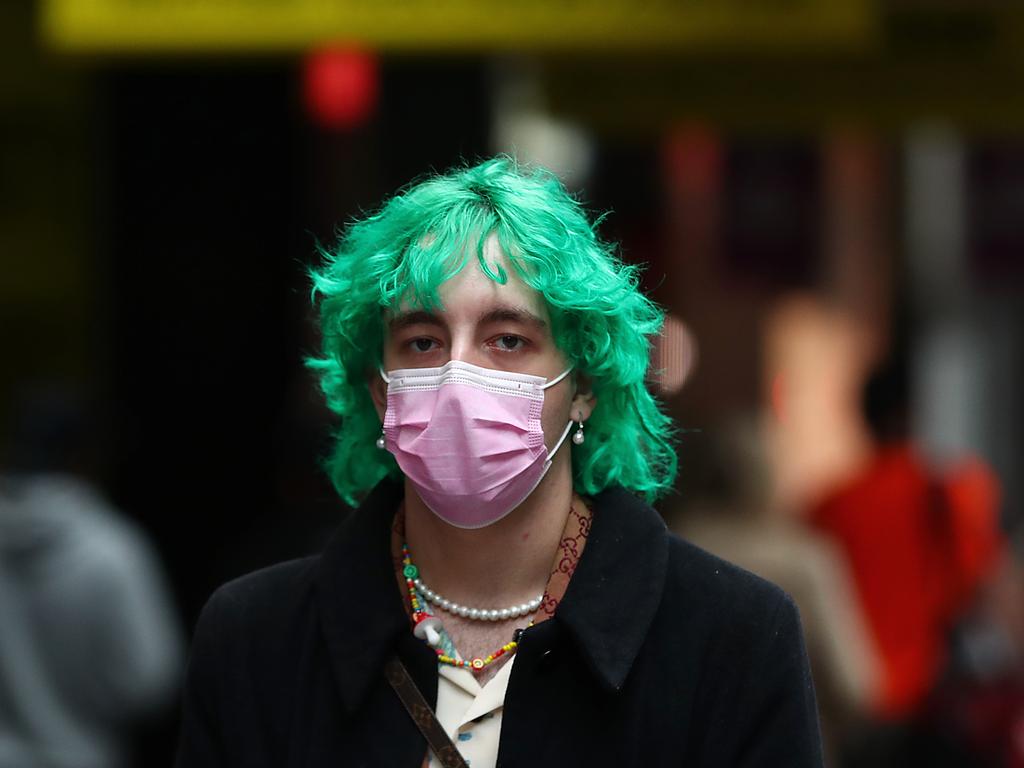 A man wears a face mask as he walks along George Street in Sydney. Picture: Mark Metcalfe