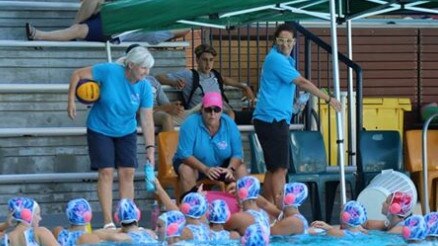 Nicola Johnson, pink cap, addresses her Mermaids under 18 water polo team.