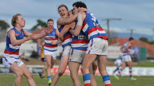 Central District players mob Josh Waldhuter after his late goal secured the Bulldogs’ 20-point triumph over Woodville-West Torrens and a finals berth. Picture: AAP Image/Brenton Edwards