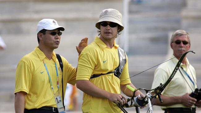 Australian archer Tim Cuddihy is congratulated at the 2004 Athens Olympics by coach Ki Sik Lee, who has since been lured back overseas.