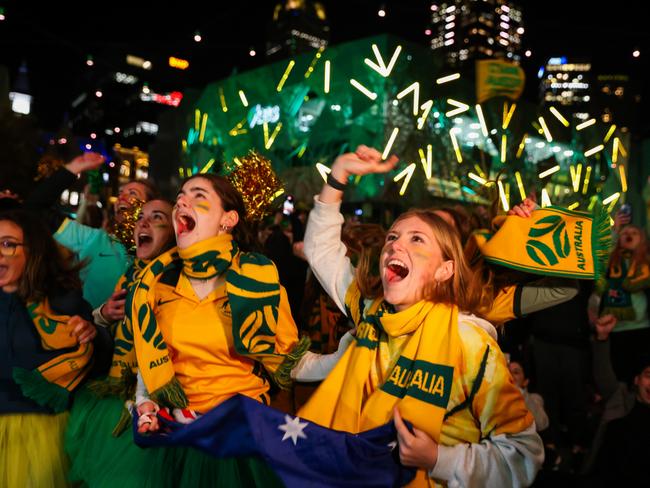 MELBOURNE, AUSTRALIA - AUGUST 07: Australian fans celebrate at Melbourne's Federation Square after watching the Matildas FIFA World Cup win their round of 16 match against Denmark, being played in Sydney, on August 07, 2023 in Melbourne, Australia. (Photo by Asanka Ratnayake/Getty Images)