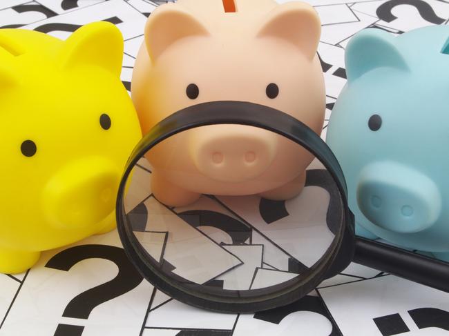 Three piggy banks under magnifying glass on question marks background. Saving money concept; superannuation saving generic