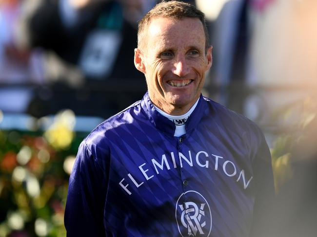 MELBOURNE, AUSTRALIA - NOVEMBER 11: Champion jockey Damien Oliver walks through a guard of honour by fellow jockeys after riding in his final race at headquarters, during Stakes Day at Flemington Racecourse on November 11, 2023 in Melbourne, Australia. (Photo by Josh Chadwick/Getty Images)