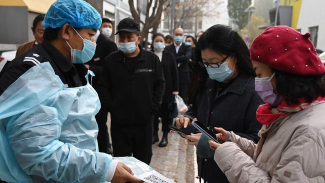 People scan a QR code to register before getting a Covid-19 coronavirus test in Beijing. Picture: Greg Baker