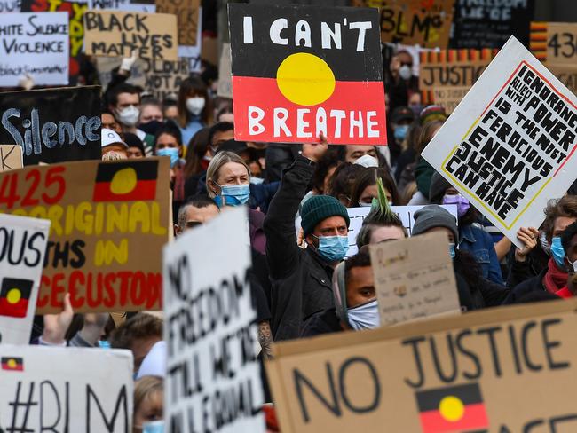 People hold up placards at a Black Lives Matter protest to express solidarity with US protestors in Melbourne on June 6, 2020 and demand an end to frequent Aboriginal deaths in custody in Australia. - Tens of thousands of Australians defied government calls to stay at home on June 6, spilling onto the streets for Black Lives Matter protests in major towns and cities across the country. (Photo by William WEST / AFP)