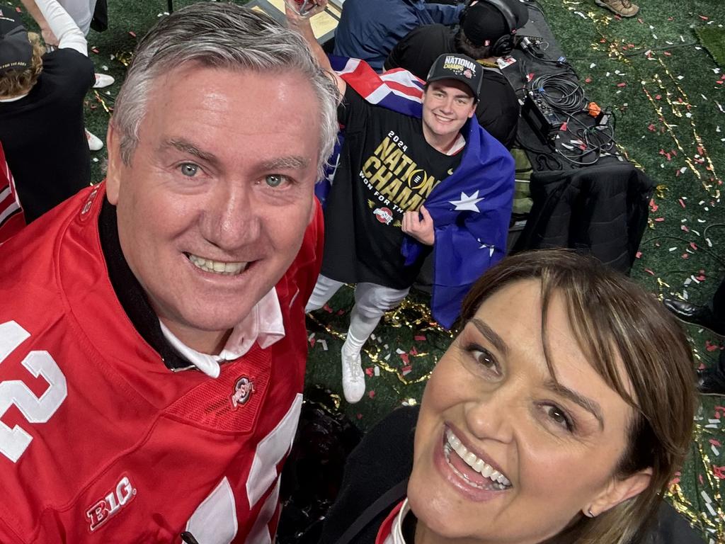 Eddie and Carla McGuire celebrate after the game with Joe on the field behind them.