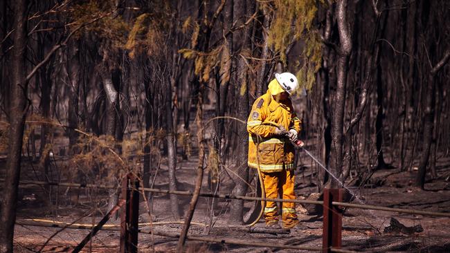 A Rural Fire Service volunteer mopping up after a fire.