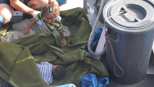 Vicky, right, laying on the tarp, and her sister Destiny after they were picked up at sea.