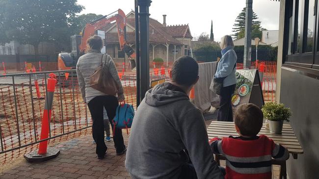 A father and son watch machinery in action as part of the King William Rd upgrade. Picture: Nicole Sumracki