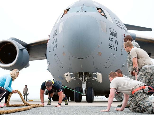 AFP commander Cmdr. Grant Edwards, Australia’s strongest man, pulling an aircraft. Picture: Alamy