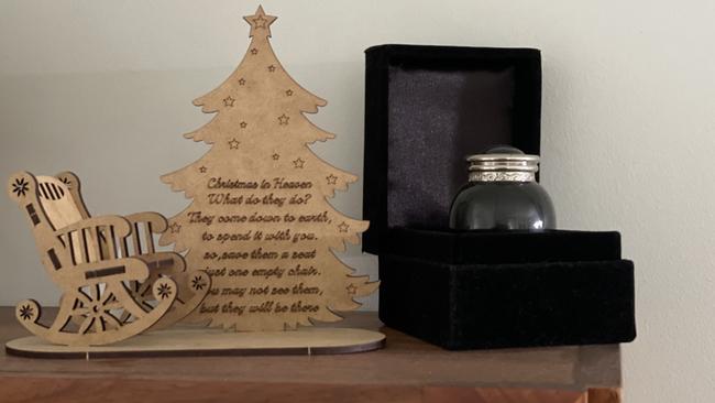 A small urn containing some of his ashes sits on a wooded cabinet in her home. Picture: Janessa Ekert