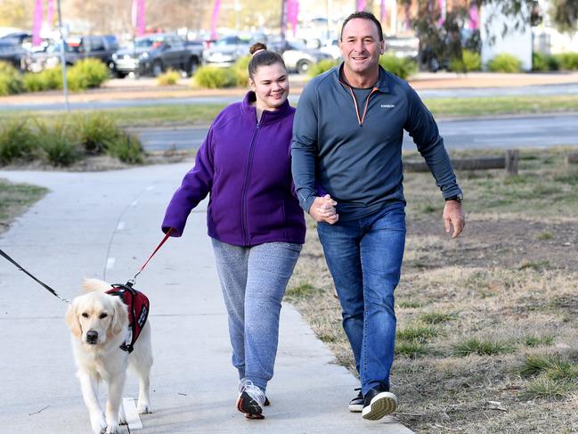 Canberra Raiders coach Ricky Stuart with his daughter Emma Stuart and their companion dog Cosmo, who helps Emma. Picture: AAPImage/Tracey Nearmy