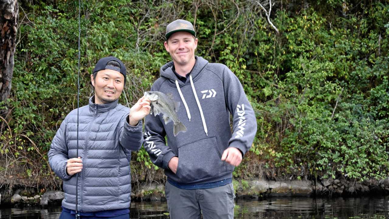 SMALL BEGINNINGS: Zaiyu Hasegawa, with bass fishing champion Braden Schuch, started small with this Australian bass, which he quickly returned to the water. It was the first of the species, or any Australian native fish, he had ever caught. Picture: Arthur Gorrie