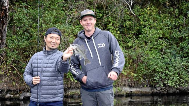 SMALL BEGINNINGS: Zaiyu Hasegawa, with bass fishing champion Braden Schuch, started small with this Australian bass, which he quickly returned to the water. It was the first of the species, or any Australian native fish, he had ever caught. Picture: Arthur Gorrie