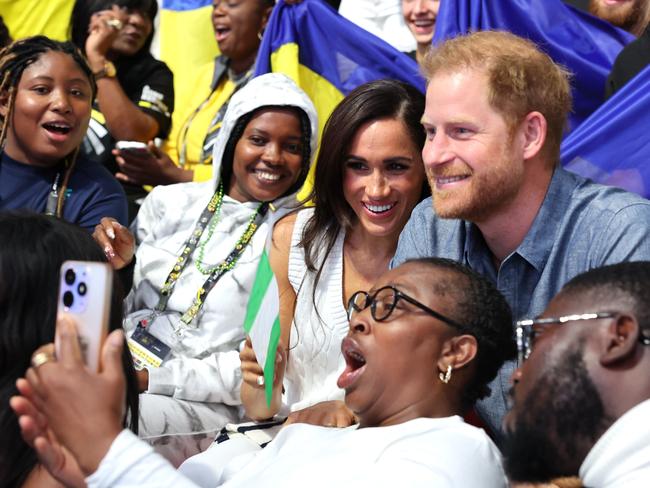 Prince Harry and Meghan Markle take selfies with fans at the Invictus Games. Picture: Getty Images for the Invictus Games Foundation