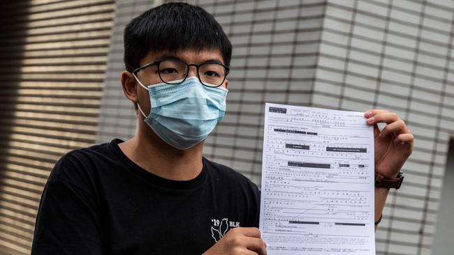 Pro-democracy activist Joshua Wong holds up a bail document after being arrested in Hong Kong in September for unlawful assembly. Picture: AFP