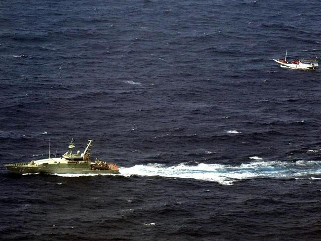 An Australian Navy vessel sailing alongside a wooden boat carrying up to 180 asylum seekers on the waters off Christmas Island in 2012. Picture: Indonesian National Search and Rescue Agency