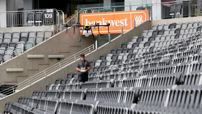 An operator guides the germ-destroyer, which sprays water on seats, around Bankwest Stadium. Picture: Toby Zerna