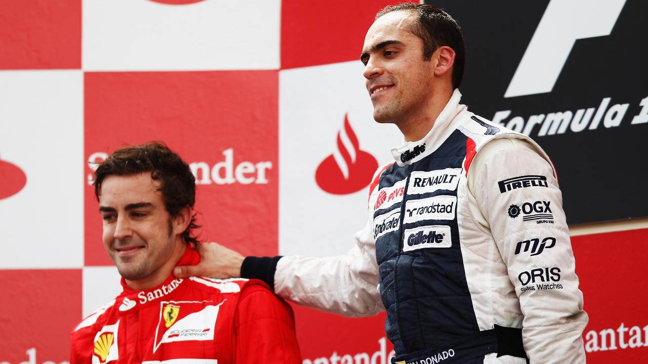 Pastor Maldonado (R) on the podium with then-Ferrari driver Fernando Alonso in Spain in 2012.