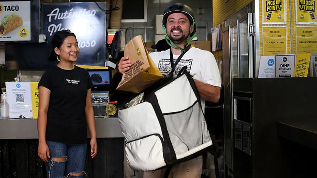 Brazilian Uber Eats rider Lua Portela picks up an order from Bipana Khalsa at Guzman y Gomez in Bondi Junction, eastern Sydney on Monday. Picture: Jane Dempster