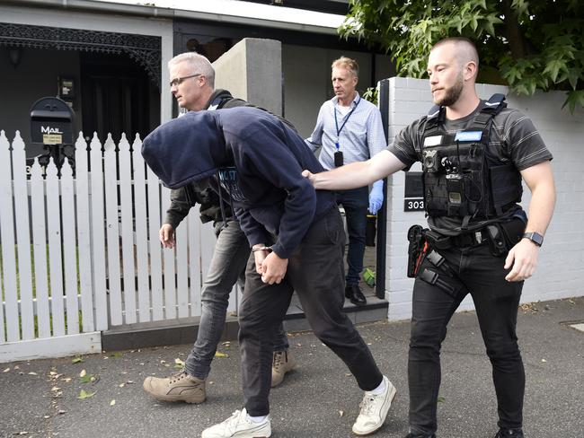 Police lead a man from a South Melbourne home. Picture: Andrew Henshaw