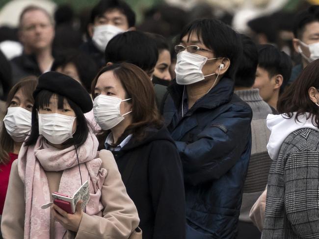 TOKYO, JAPAN - FEBRUARY 02: People wearing masks wait to cross a road  in the Shibuya district on February 02, 2020 in Tokyo, Japan. Japan reported 20 cases of Wuhan coronavirus infections as the number of those who have died from the virus, known as 2019-nCoV, in China climbed to over 300 and cases have been reported in other countries including the United States, Canada, Australia, Japan, South Korea, India, the United Kingdom, Germany, France, and several others.  (Photo by Tomohiro Ohsumi/Getty Images) *** BESTPIX ***