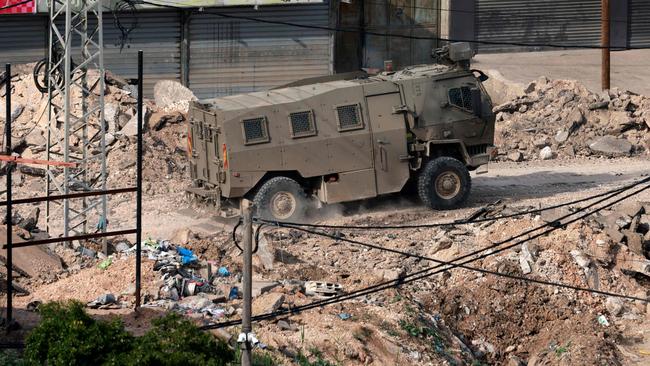 An Israeli military vehicle drives along a damaged street in the al-Fara camp for Palestinian refugees, south of Jenin in the occupied West Bank on February 2. Picture: AFP