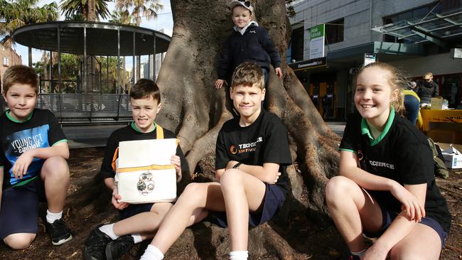 Manly Village students have come up with an invention that is a tracking device to find toddlers. James Renton-Schmidt 9, Archie Partington 11, Tal Carmel 10 and Olivia Renton-Schmidt 11 plus toddler with tracking hat is Bertie Partington 4.