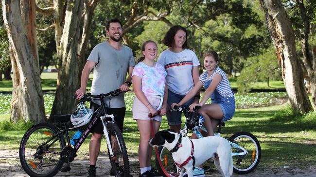 Scott Sanders with daughters Zara, Evie and Adele and Charlie the dog enjoying Centennial Park on Sunday ahead of a statewide shut down. Picture: Jane Dempster