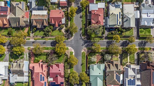 Aerial view of leafy eastern suburban houses on 4-way cross road intersection in Adelaide, South Australia: directly above, rooftop solar, trees. Housing property generic