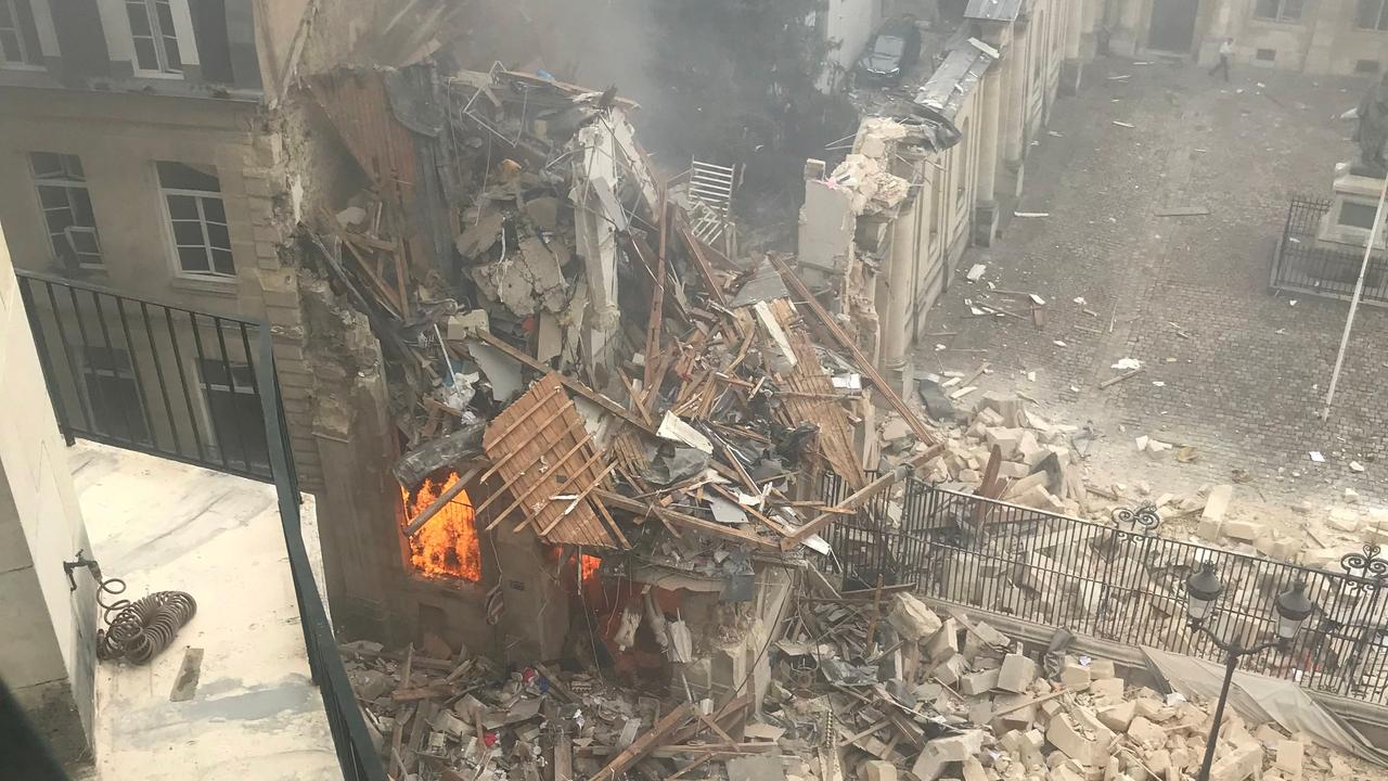 Flames emerged from the destruction and rubble in the immediate aftermath of an explosion in a building on Rue Saint-Jacques. (Photo by Gregory Custo / AFP)