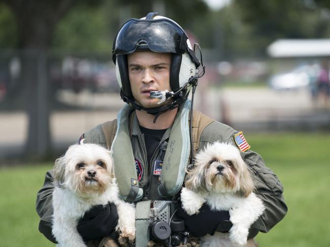 Naval Aircrewman, 2nd Class Jansen Schamp, a native of Denver, Colorado and assigned to the Dragon Whales of Helicopter Sea Combat Squadron 28, rescuing two dogs at Pine Forrest Elementary School, a shelter that required evacuation after flood waters from Hurricane Harvey reached its grounds on August 31, 2017 in Vidor, Texas. The mission resulted in the rescue of seven adults, seven children and four dogs. Picture: AFP