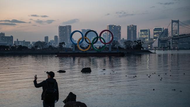 A man takes a photograph near the Olympic Rings in Tokyo, Japan. Picture: Getty