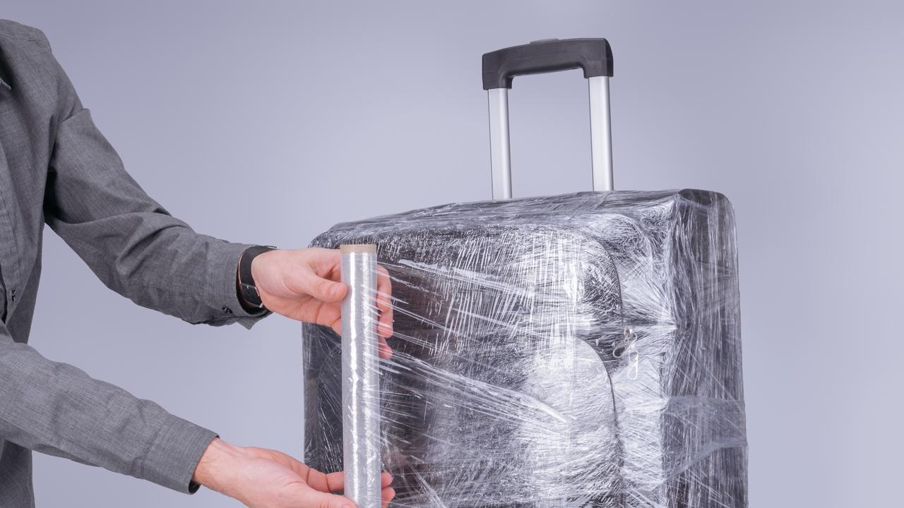 plastic wrapping suitcases at airport