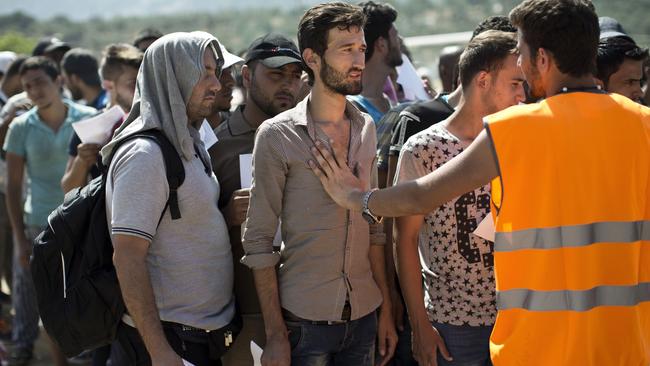 Migrants wait to complete their registration procedure by the police at a new registration center held at a stadium on the Greek island of Lesbos on September 8, 2015. The Greek island of Lesbos is "on the verge of explosion" with violence erupting as the more than 15,000 mainly Syrian refugees push local resources to the limit, the immigration minister said on September 7. Yiannis Mouzalas told To Vima radio that boats taking refugees to the Greek mainland would soon be using a second port to ease pressure on the island of 85,000 inhabitants. AFP PHOTO / ANGELOS TZORTZINIS