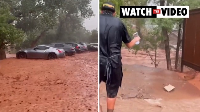 Row of luxury vehicles almost swept away in flood water