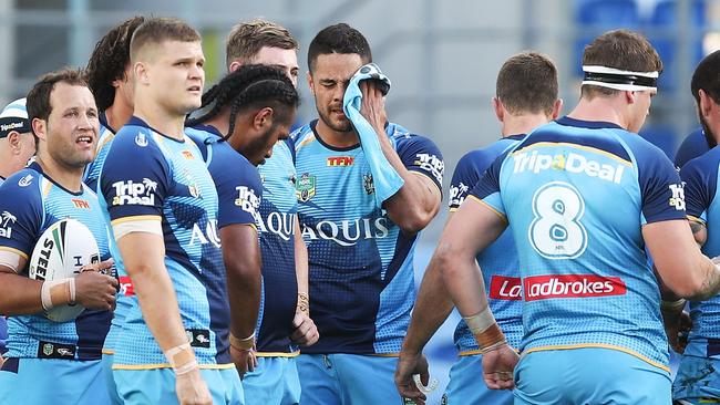 Jarryd Hayne wipes his face as the rest of the team look on.