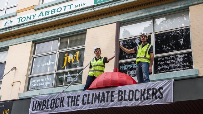 Protesters hang a giant toilet plunger from Tony Abbott’s electorate office in Manly. Picture: Supplied