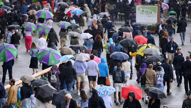 LONDON, ENGLAND – JUNE 27: Staff and spectators hold umbrellas in the rain during Day One of The Championships Wimbledon 2022 at All England Lawn Tennis and Croquet Club on June 27, 2022 in London, England. (Photo by Justin Setterfield/Getty Images)