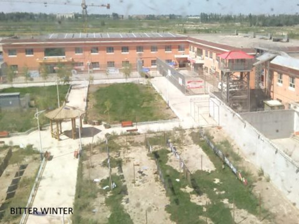 The 4m-high concrete and barbed wire walls enclose a garden and exercise space — overlooked by a red-roofed watch tower — within the alleged detention facility. Picture: Bitter Winter