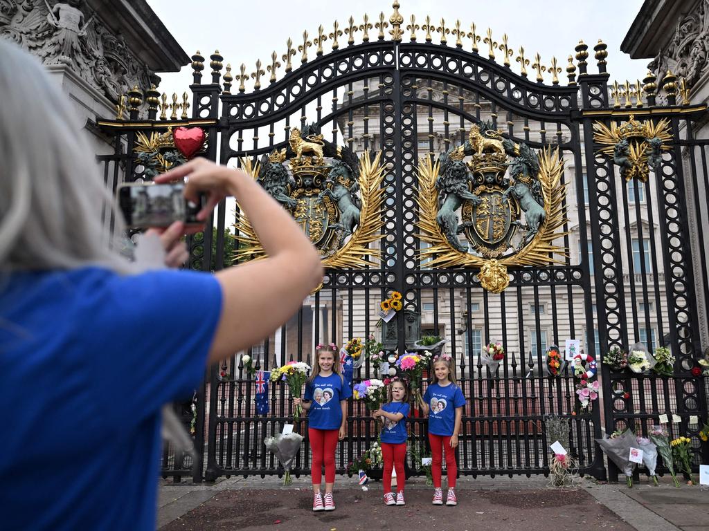 Children have their photograph taken outside Buckingham Palace. Picture: AFP