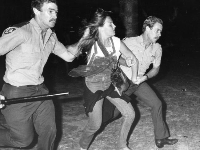 Police arrest a girl at the 1984 Glenelg riots.